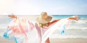 Mujer con los brazos abiertos en la playa