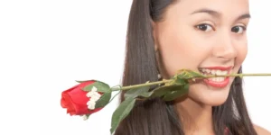 Mujer con rosa en la boca