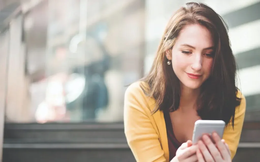 mujer con celular en la mano