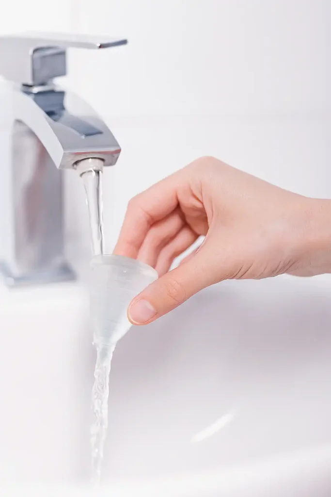 Cómo quitar el mal olor de tu copa menstrual mano Mujer lavando su copa menstrual para quitar el mal olor siguiendo la guía de Angelcup