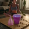 mujer meditando en sala con copa menstrual lila