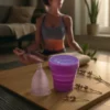 mujer meditando en sala con copa menstrual rosa