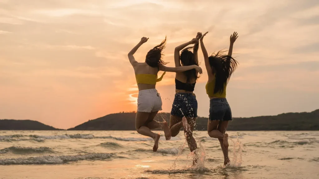 mujeres saltando en la playa
