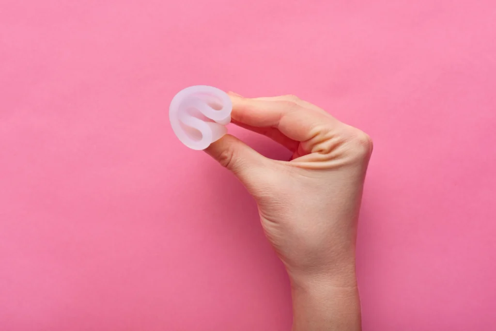 cerrar-vista-mujer-sosteniendo-copa-menstrual-aislada-sobre-rosa-periodo-mujer-copa-menstrual-manos