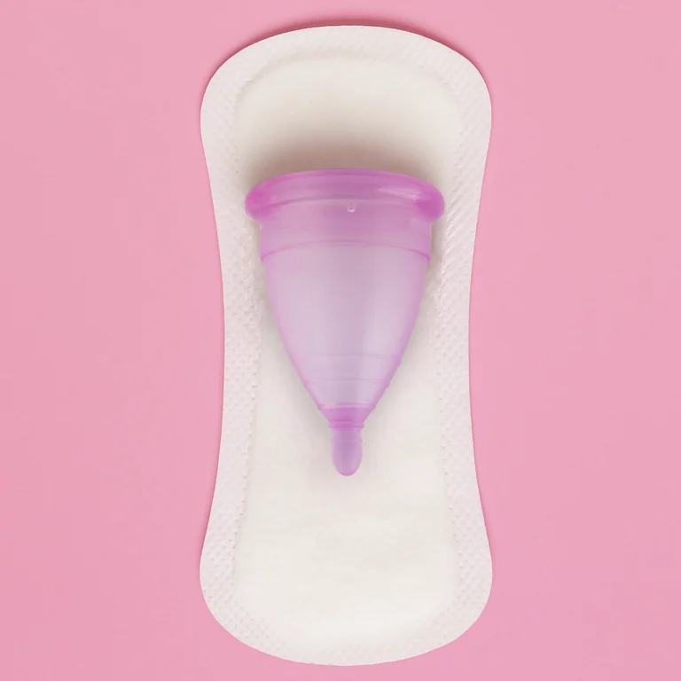 Copa menstrual vs toallas sanitarias, ilustrando la elección entre comodidad sostenible y productos desechables.