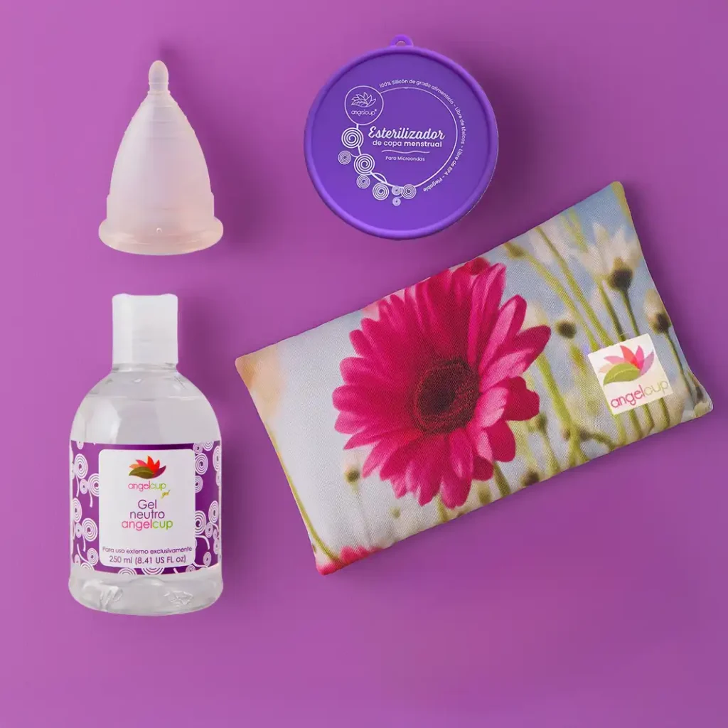 Kit de soluciones Angelcup para una menstruación sostenible: copa menstrual, vaso esterilizador y cojín anticólicos sobre un fondo natural.