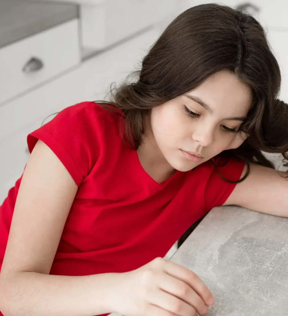 Adolescente reflexiona en su cocina sobre los cambios de la pubertad, preparándose para hablar de su primera menstruación con confianza