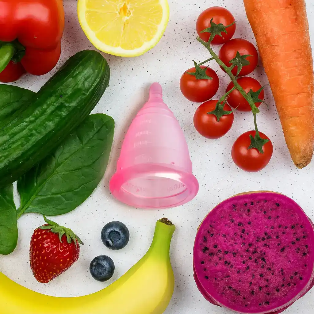 Alimentos saludables y una copa menstrual Angelcup, un ritual de autocuidado para la salud física y mental durante la menstruación