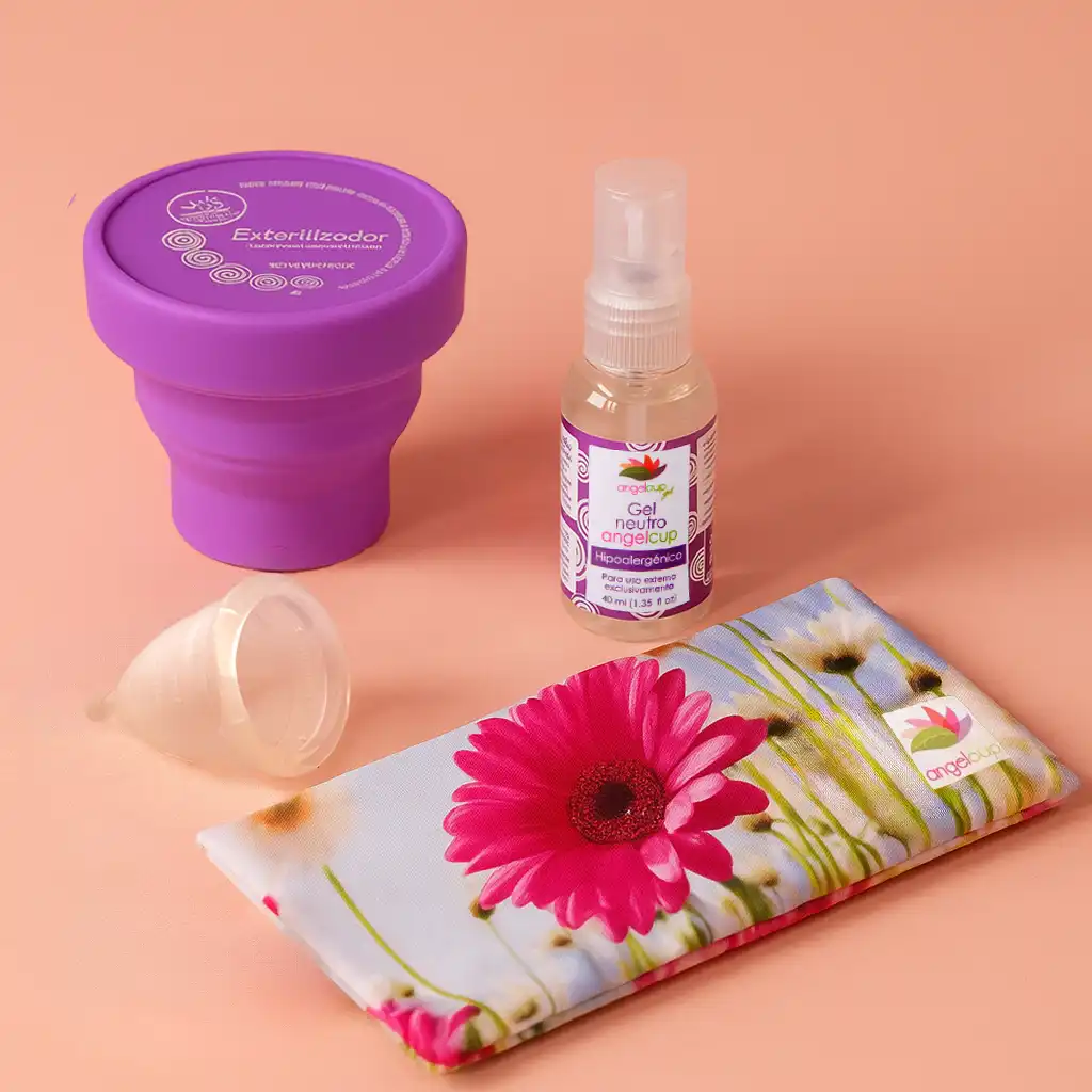 Kit de productos Angelcup para dormir bien durante la menstruación, incluyendo la copa menstrual, el cojín anticólicos y el gel neutro sobre un fondo rosa.