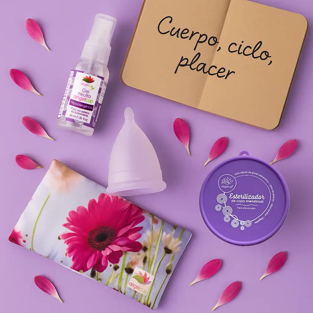 Productos Angelcup como la copa menstrual y el cojín de semillas en un arreglo sobre fondo lila que inspira autocuidado y bienestar femenino.
