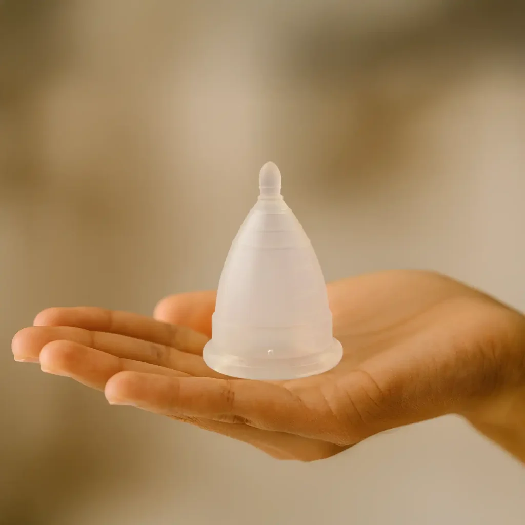 Manos de una mujer sosteniendo una copa menstrual Angelcup con cuidado, representando la decisión consciente de elegir un producto 100% mexicano para su bienestar íntimo.