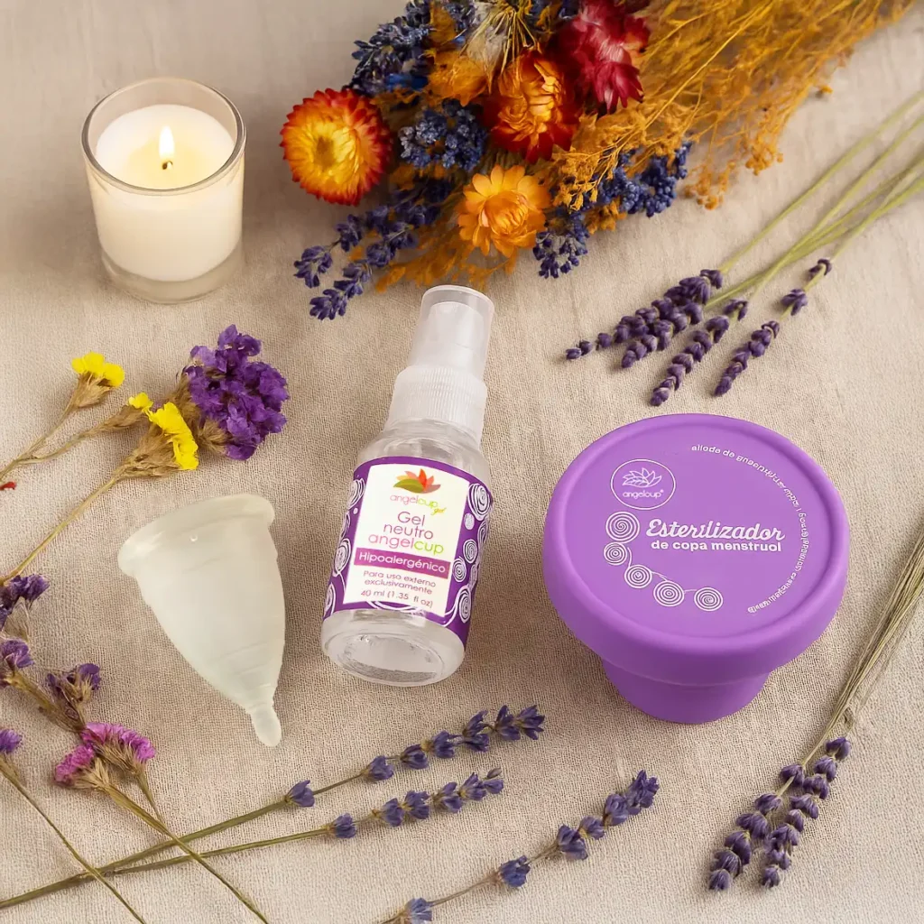 Flatlay cálido con productos Angelcup: copa menstrual, jabón neutro y vaso esterilizador en un entorno natural, que simboliza autocuidado, armonía y sostenibilidad menstrual.