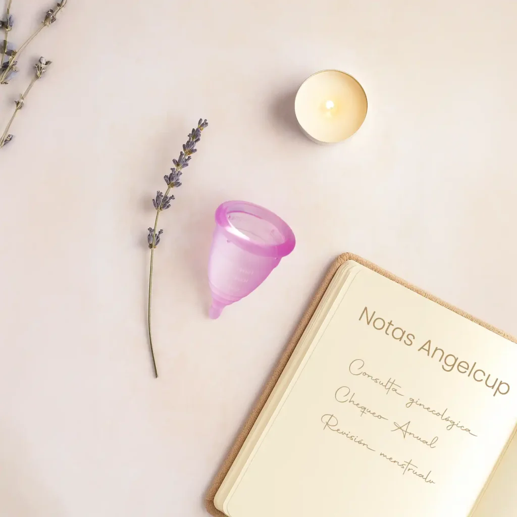 Copa menstrual Angelcup lila sobre superficie suave. Autoconocimiento, salud ginecológica, observación del flujo menstrual, prevención de cáncer de útero.