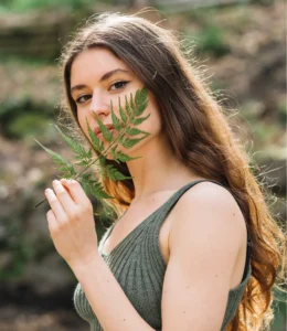 Día mundial de la educación ambiental Copa Menstrual Sostenible mujer oliendo una planta que sostiene con su mano