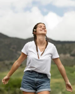 Mujer sonriendo al aire libre, representando la libertad de un ciclo sostenible gracias a la copa menstrual y el ahorro de agua.